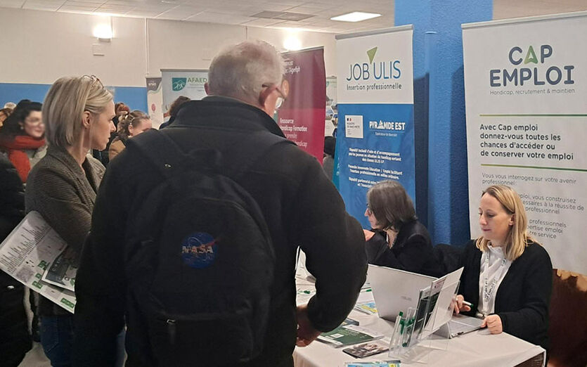 Des bénéficiaires devant le stand CAP EMPLOI et celui de JOB'ULIS.