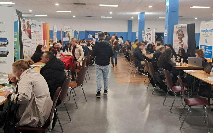 Une allée du forum composée de plus de 10 stands avec quelques personnes qui marchent au milieu. C'était le début du forum.